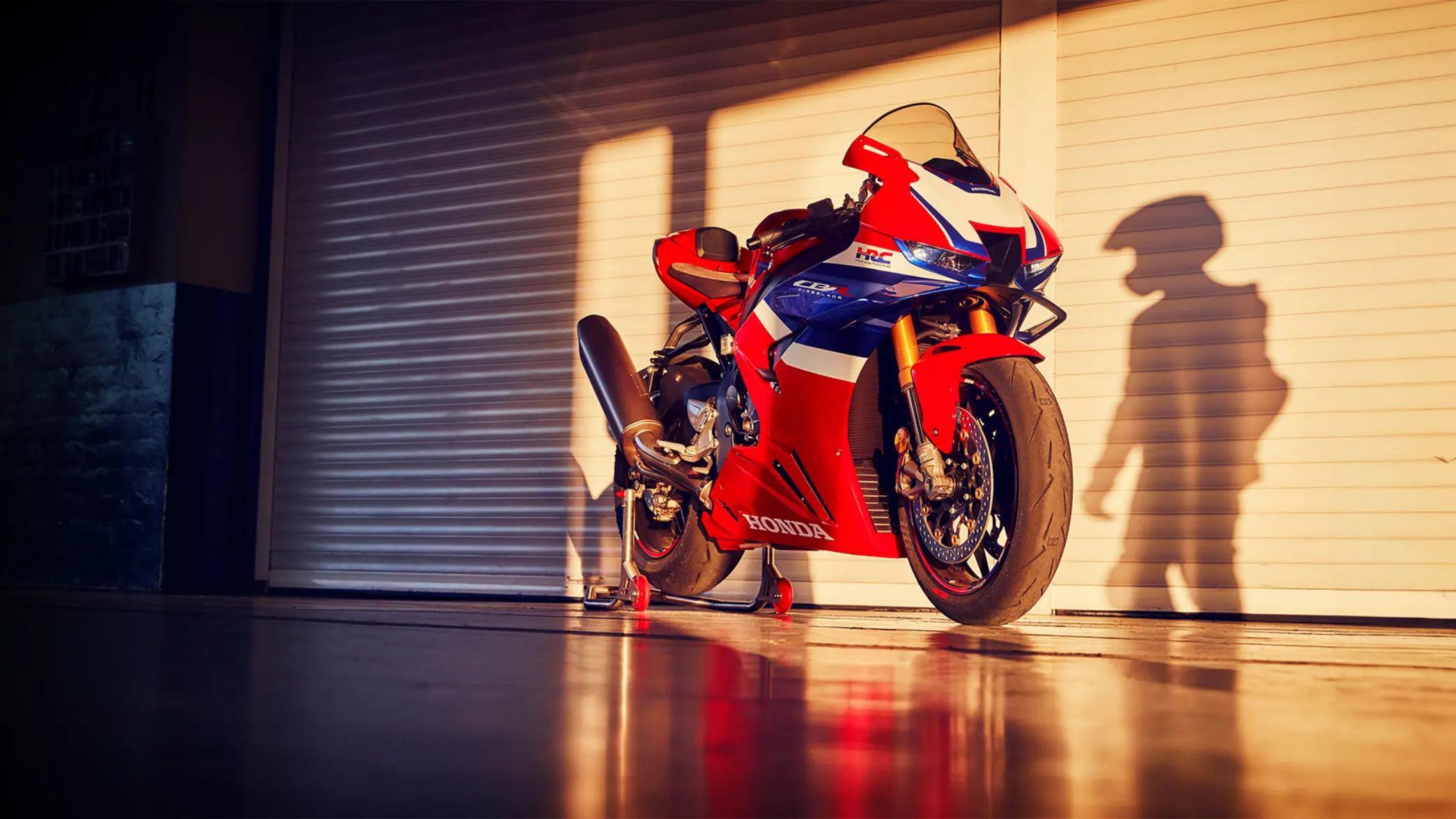 Honda CBR1000RR-R Fireblade Motorrad steht vor einem geschlossenen Garagentor.