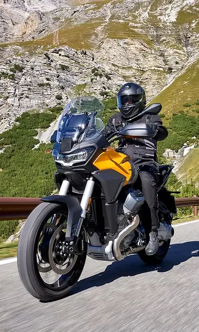 Ein Motorradfahrer auf einer kurvigen Bergstraße, vermutlich auf einem Stelvio-Modell.